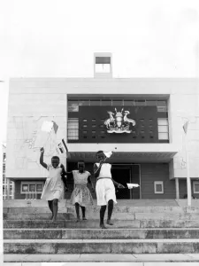 Kampala, Uganda: Three young girls run down the steps in front of the new Parliament building here