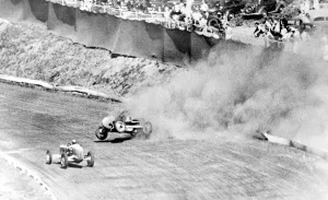 Lacatiers a blazing car hurling through the air in a column of smoke whichconceels