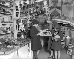 Lady Verney (striped scarf) in the toy and bookshop she has opened in the garage