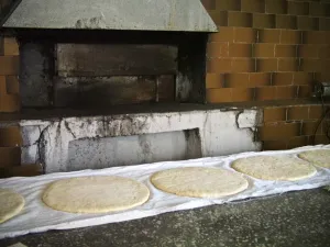 Vacation Prints: Large round flat loaves of bread rising on clean cloths on counter of quayside bakery