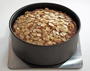 Sweet Collection: Light fruit cake topped with almonds in tin credit: Marie-Louise Avery / thePictureKitchen