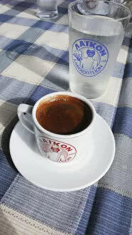 Caffeine Collection: Little cup of strong Greek coffee, with glass of water on table of beach restaurant