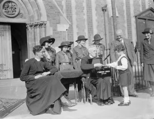 A little girl gives money to the collectors for St Barnabas Church in Eltham, Kent