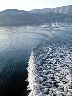 Looking back at the wake of Turkish gulet sailing among Greek islands in early morning