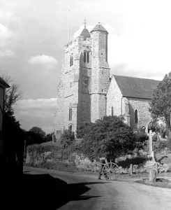 Topography Prints: Man rolling a cartwheel along past a churchyard memorial A TopFoto