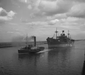 Ships Prints: Merchant ship under tow from a paddle steamer tug. 1936