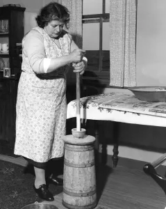 Homemade Prints: Miss Peggy Macleod making butter using the plunger in Daliburgh South Uist Outer