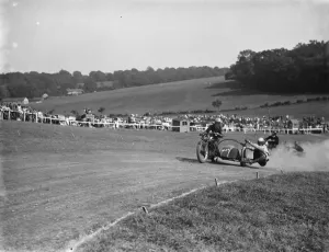 Motorcycling races at Brands Hatch. Two of the side car bikes jostle for position