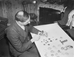 Stones Prints: Mr Charles Epps, a beach comber, uses a magnifying glass to inspect his find in