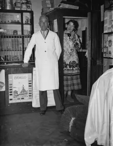 Mr George May, Postmaster of Downe, Kent by his Post Office counter with his wife