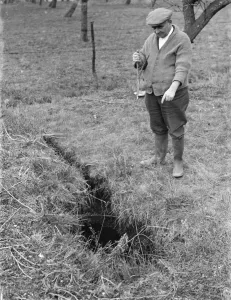 Stick Prints: Mr Searles using a water diviner, points to where he believes water is available