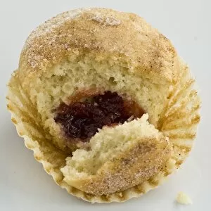 Inspiration Collection: Muffin with sugary top filled with jam (jelly), broken open to show filling. A muffin