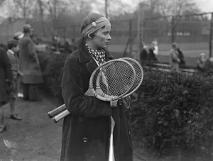 New fashion in tennis headwear. Miss J Mc Alpine plays with watch in bandou
