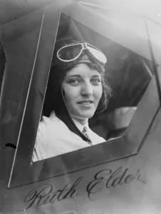 Goggles Prints: New York to Paris flight. Miss Ruth Elder looking out of cockpit. 1927