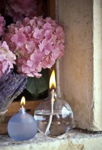 Decorative Prints: Two oil burner lamps with pink hydrangea and lavender in window niche credit: Marie-Louise