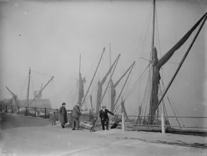 Old men on the riverside by the moored Thames sailing barges at Northfleet, Kent