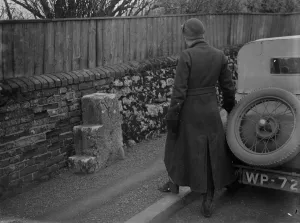 Spare Tyre Prints: Old and new. A woman motorist looks at mounting blocks for horse riders at the roadside