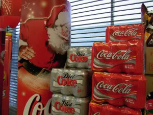 Beard Prints: Six can packs of Coca-Cola and Diet Coke next to a giant poster of Father Christmas