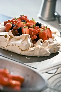 Pavlova with fresh berries on kitchen worktop credit: Marie-Louise Avery / thePictureKitchen