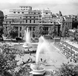 Landmarks Prints: People enjoying the sunshine and the fountains in Trafalgar Square, London, England