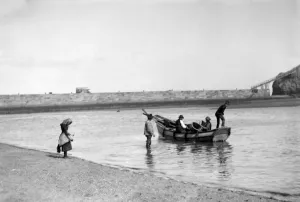 Fishing Prints: People out fishing from a Coble ( a locally made fishing boat ) at low tide, near