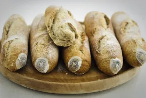 Cooking Prints: Pile of stoneground wholemeal organic baguettes on woden board credit: Marie-Louise