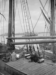 Pupils from the art school sit on the deck of a Thames Barge drawing pictures in
