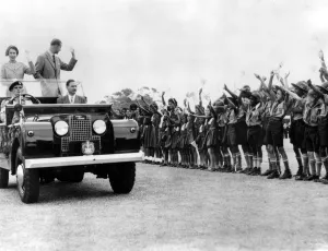 Queen Elizabeth II and the Duke of Edinburgh wave smiling acknowlegements of