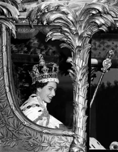 The Queen rides in the golden State Coach into Buckingham Palace at the end of her