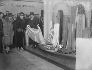 Queen watches fashion parade at British textile exhibition. The Queen, accompanied