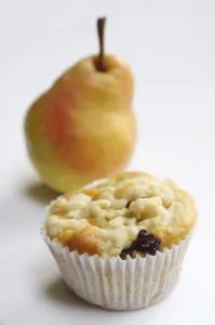 Sweet Prints: Raisin muffin in plain paper case, topped with grated pear and with whole pear behind