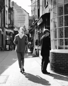 Rear view of woman wearing a mohair jumper and headscarf walking through the Lanes