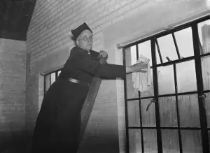 Vicar Prints: The Reverend M Cox cleaning windows in Swanscombe, Kent. 1937