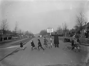Crossing Prints: Road attendant from Kent County Council, holding a sign, helps children in St Mary
