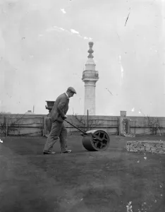 Rolling along on a London roof putting green. A green roller is being used
