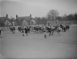Teacher Prints: School children rush out onto the school playground at break time in Erith, Kent