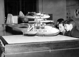 International Herald Tribune Prints: Schoolboys examine a model of the Mayo trans Atlantic flying boat at the Imperial