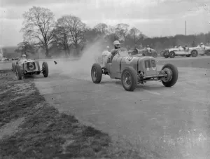 Seaman driving single handed, wins British Empire road race. Driving witout relief