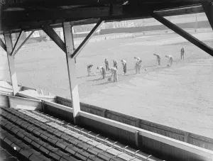 Stands Prints: Seen from the spectator stands, workers on the pitch at the Northfleet football ground