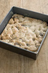 Sweet Prints: Semolina cake with figs and sesame still in its square tray on the kitchen table credit
