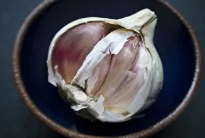 Vegetables Collection: Single bulb of garlic broken open in small bowl credit: Marie-Louise Avery / thePictureKitchen