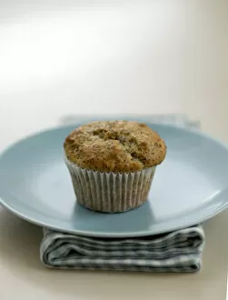 Bake Off Inspiration Collection: Single poppyseed muffin on blue plate on check napkin, on painted table. credit