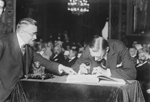 Sir Austen Chamberlain signs Golden Book of France. Sir Austen Chamberlain