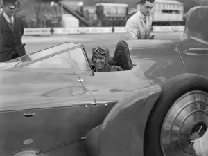 Sir Malcolm Campbell in the cockpit of Bluebird car being rolled out on Easter Monday