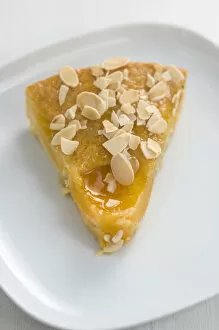 Fruit Collection: Slice of peach cake / tart sprinkled with flaked almonds credit: Marie-Louise Avery
