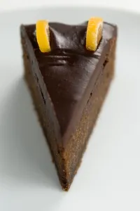 Cooking Prints: Slice of rich dense dark chocolate cake with shiny choc topping and candied orange