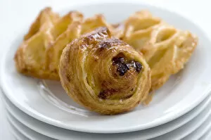 Cookery Collection: Small danish pastries on stack of white plates credit: Marie-Louise Avery / thePictureKitchen