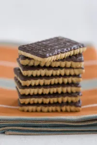 Table Setting Prints: Stack of chocolate ginger biscuits on orange napkin credit: Marie-Louise Avery
