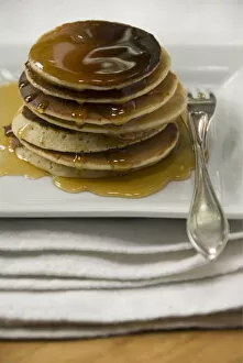 Pile Collection: Stack of Scotch pancakes on white plate with silver fork and maple syrup credit