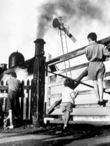 Spectators Prints: Steam train - children climbing gate to watch steam train go by - signal is down